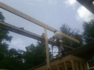 Carpenter setting a ridge beam over a new addition frame — Ice Dam Removal by Roofing Brothers in Kaylor