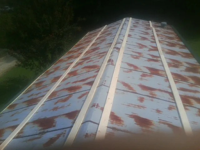 Rusted metal roof panels with new wood purlins before replacement — Storm Damage Roof Repair in Kaylor by Roofing Brothers