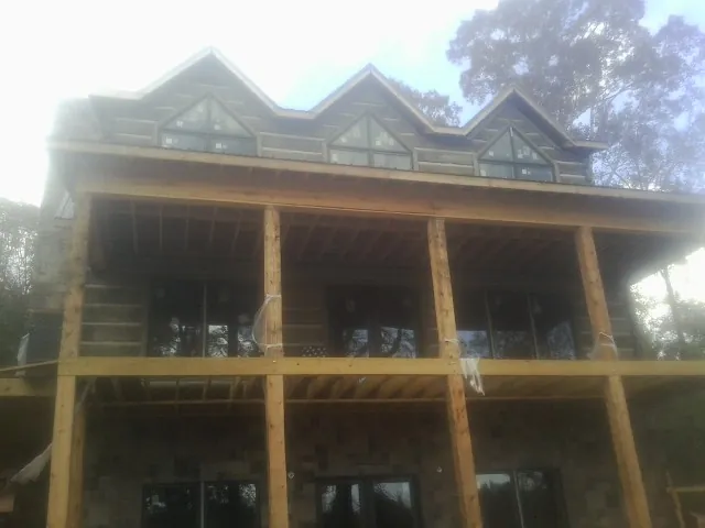 Dormers and porch framing on a large log home under construction — Roof Coating work by our crew in Kaylor